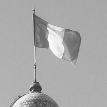 A black-and-white photograph of a vertical tricolor flag